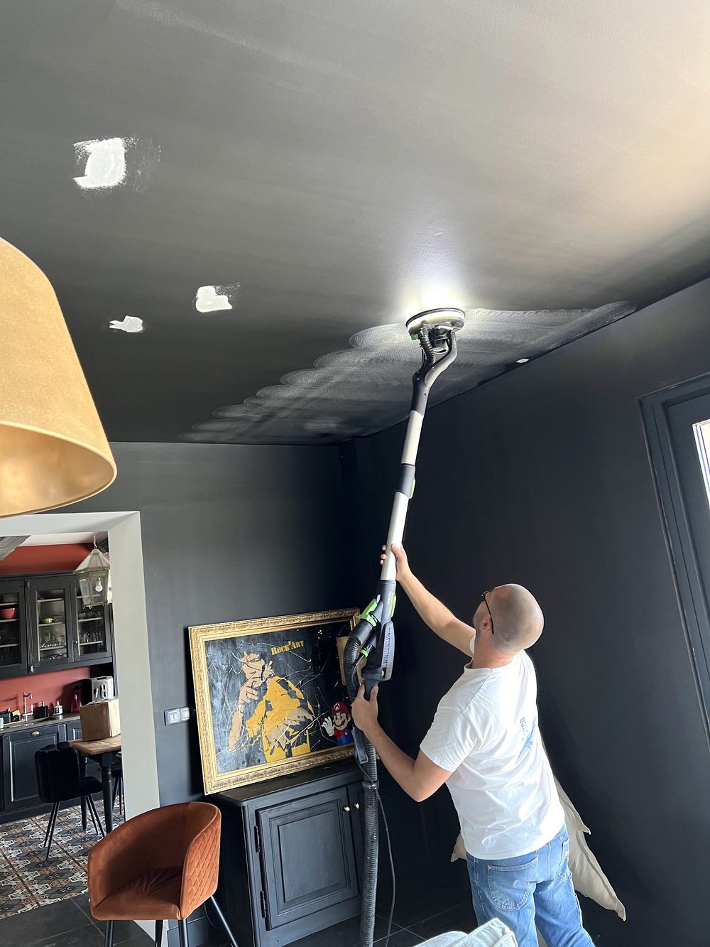 Arnaud ponçant un plafond à la girafe avant la mise en peinture